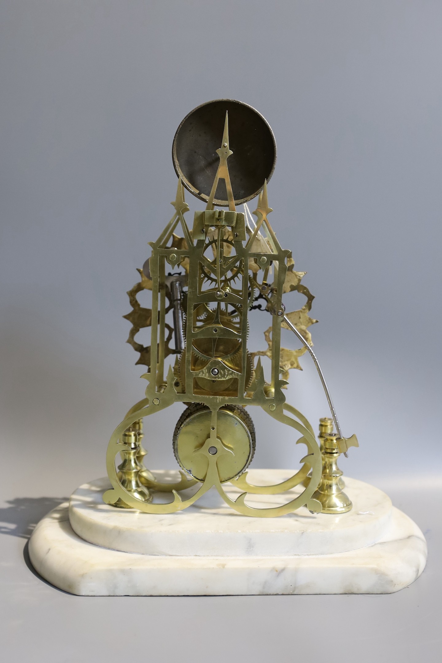 A 19th century brass skeleton mantel clock, under glass dome, with marble plinth, passing strike, the single fusee movement, with passing strike and a pierced enamelled chapter ring, height 36cm
